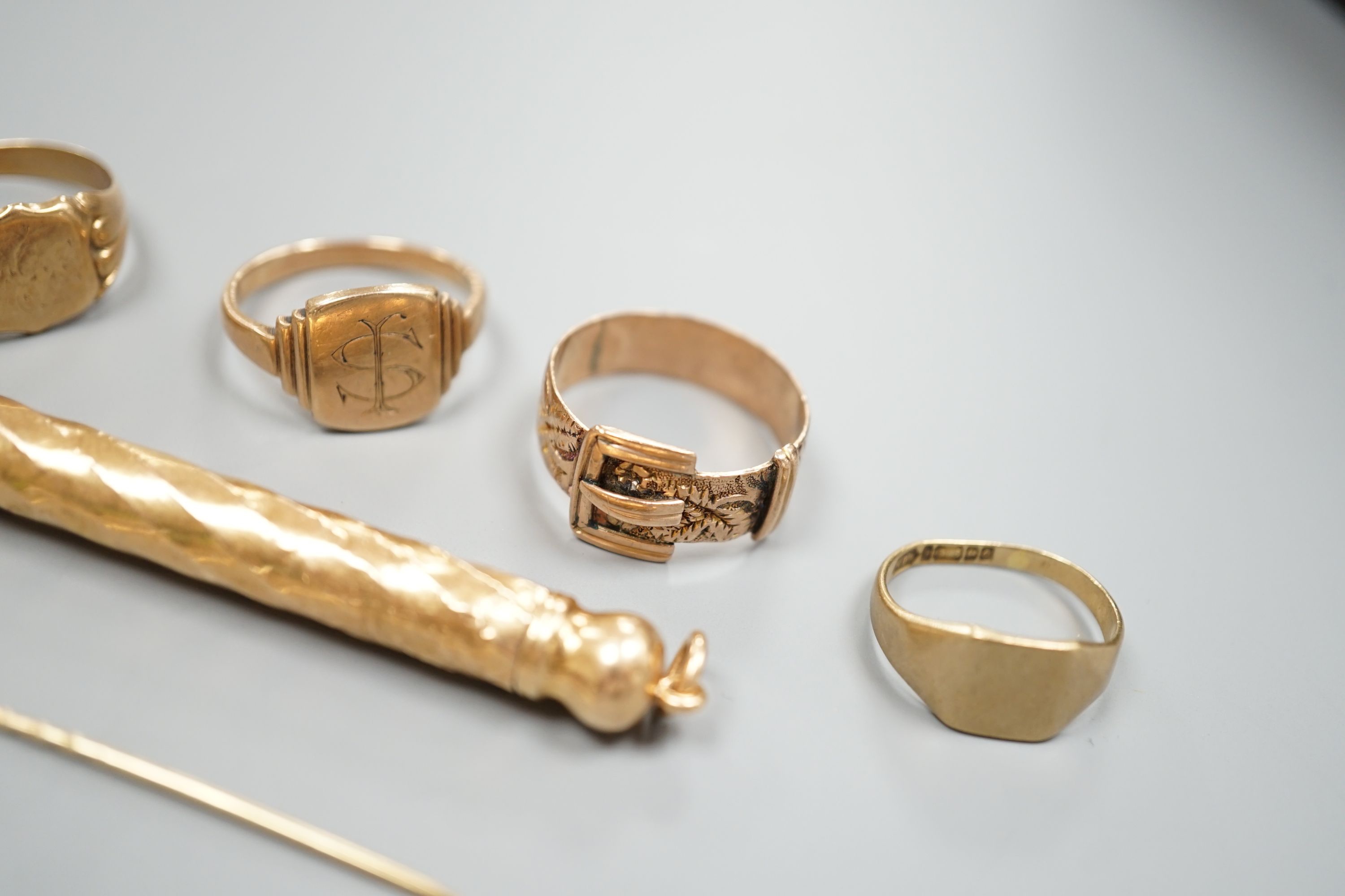 Four assorted 9ct rings including a Victorian buckle ring, 14 grams, two stick pins including part 15ct, a pair of yellow metal ear clips and a yellow metal overlaid propelling pencil.